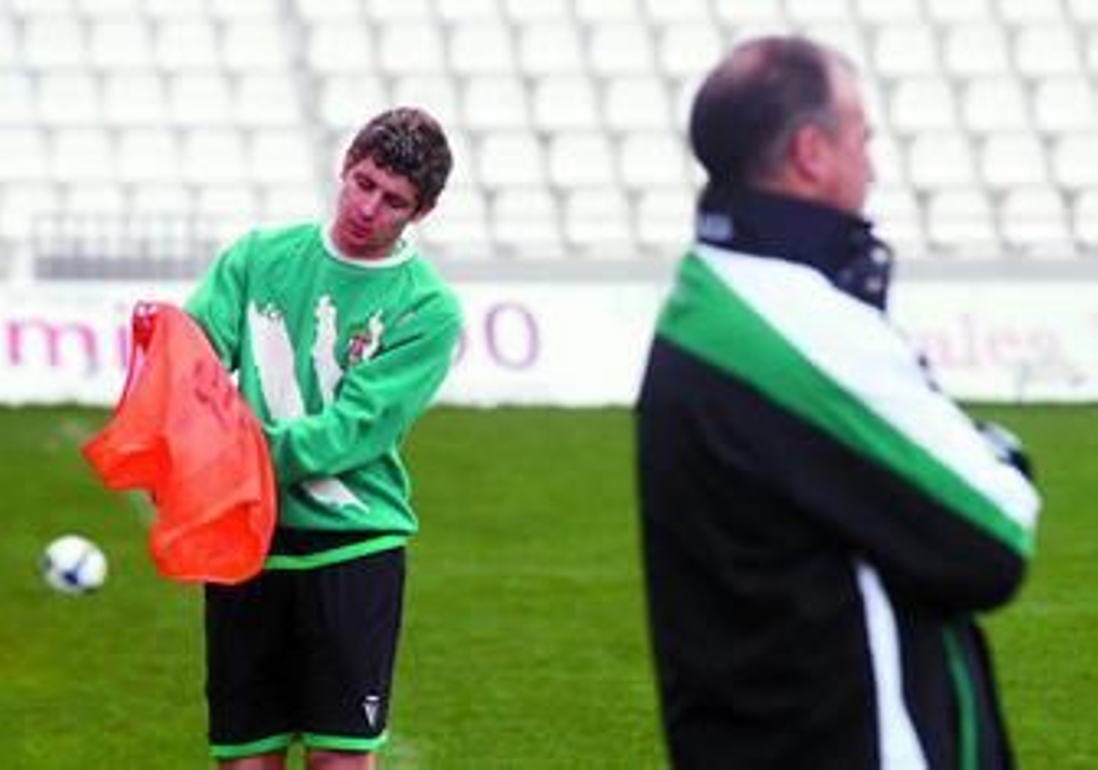 Javi Flores se pone un peto mientras Luna Eslava supervisa un entrenamiento en El Arcángel.