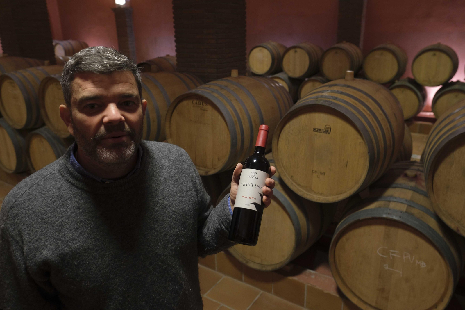 Rodrigo Nieme, enólogo de la bodega muestra una botella de Cristina en la sala de barricas.