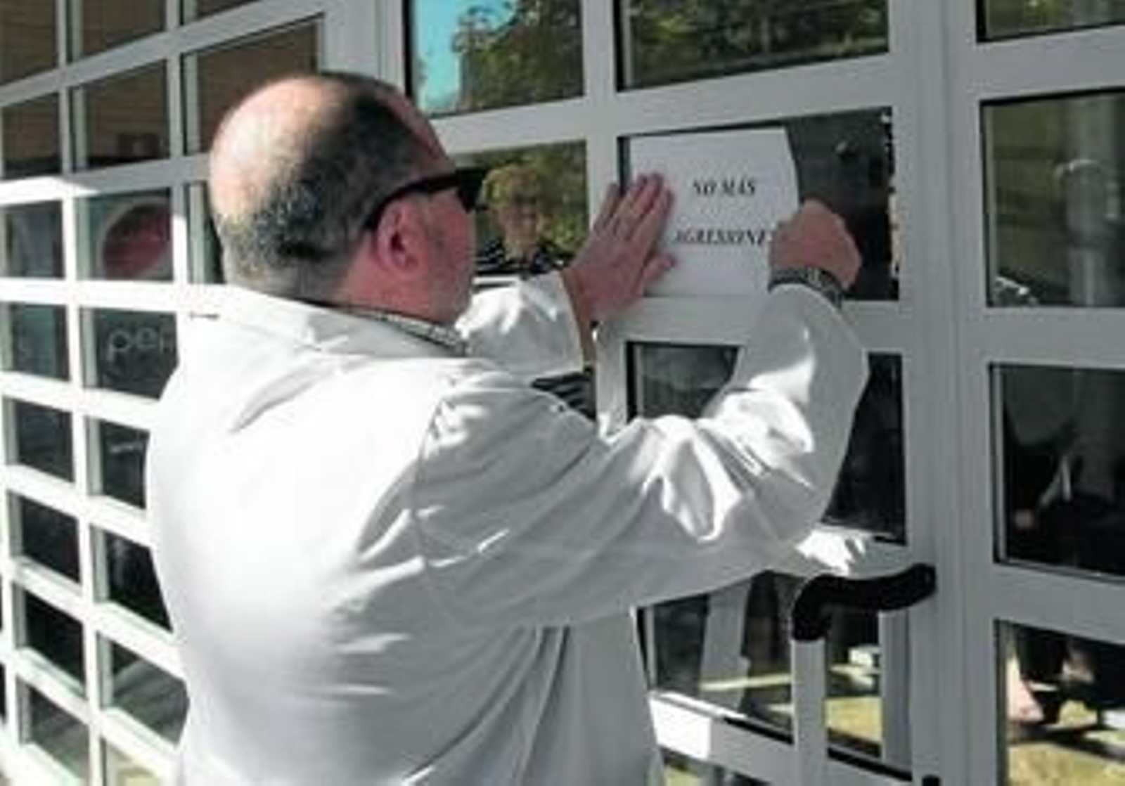 Un profesional sanitario cuelga un cartel pidiendo que se termine con la violencia en las consultas.