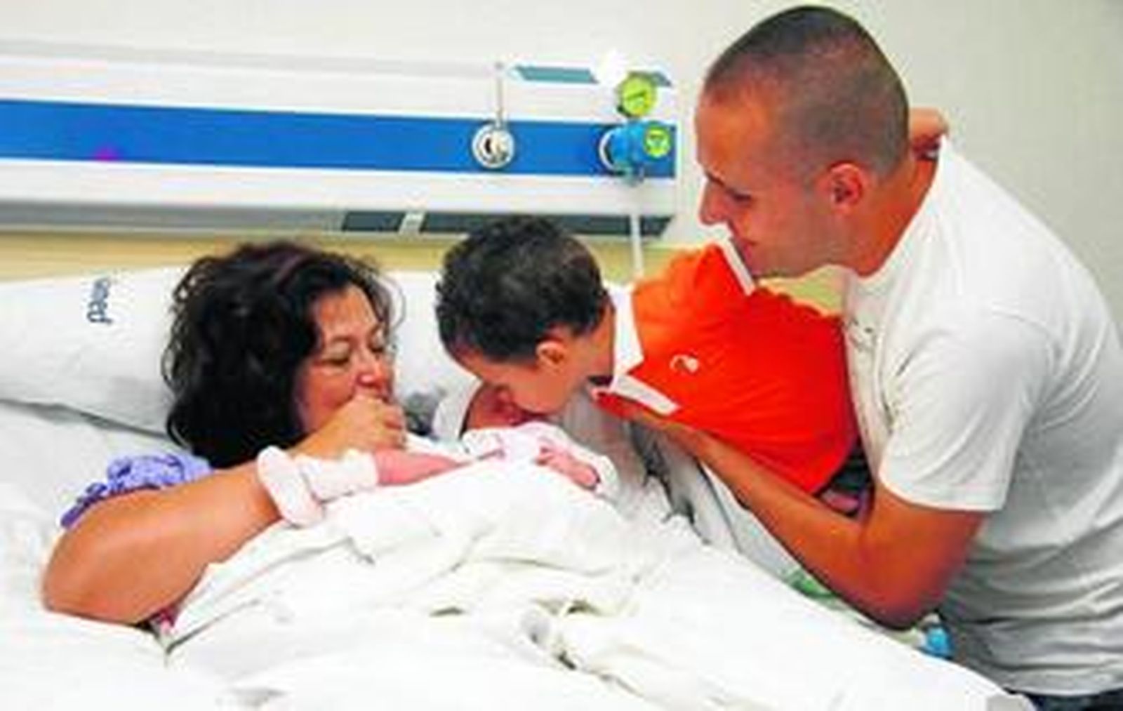 El primer bebé que nace en el nuevo hospital privado, junto a su familia.