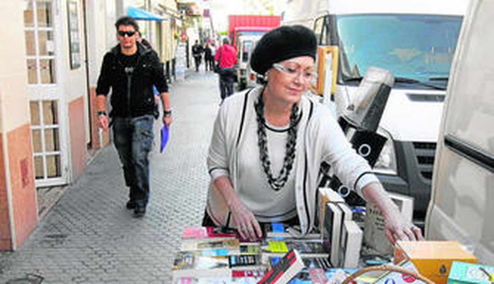 Esperanza Alcaide coloca los libros en su 'expositor callejero' de la librería El Gusanito Lector.