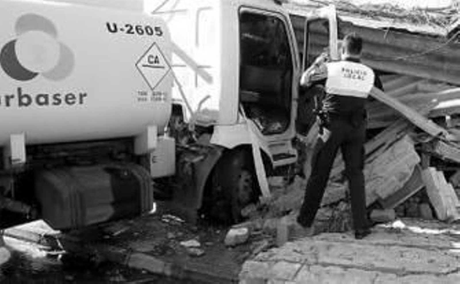 Un policía local fotografía al camión siniestrado.