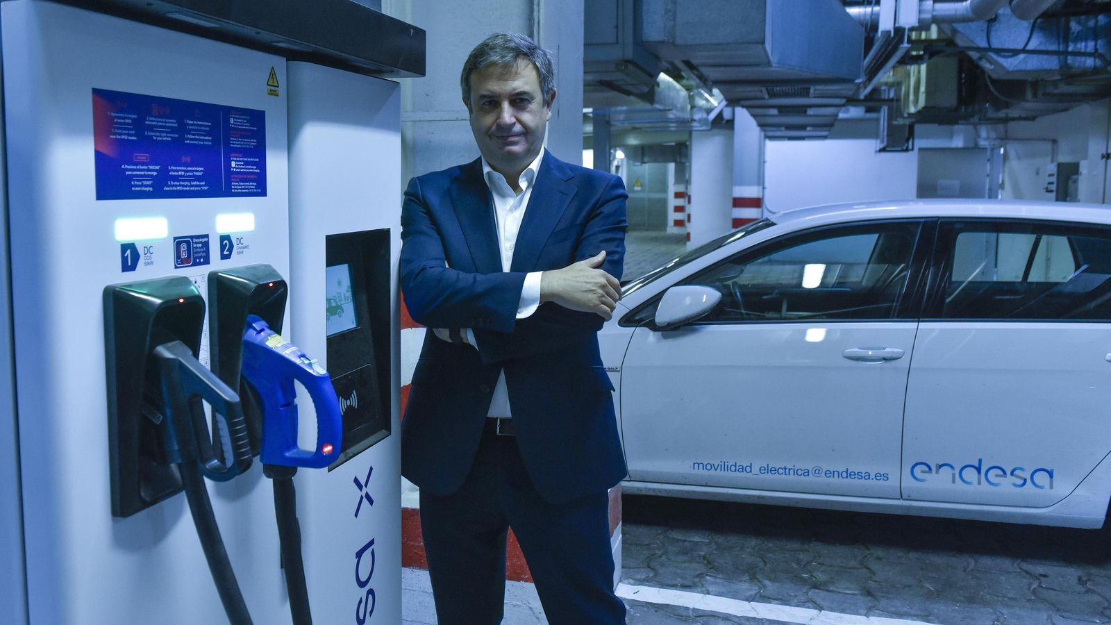 Rafael Sánchez Durán posa junto a un cargador y un vehículo eléctrico de Endesa.