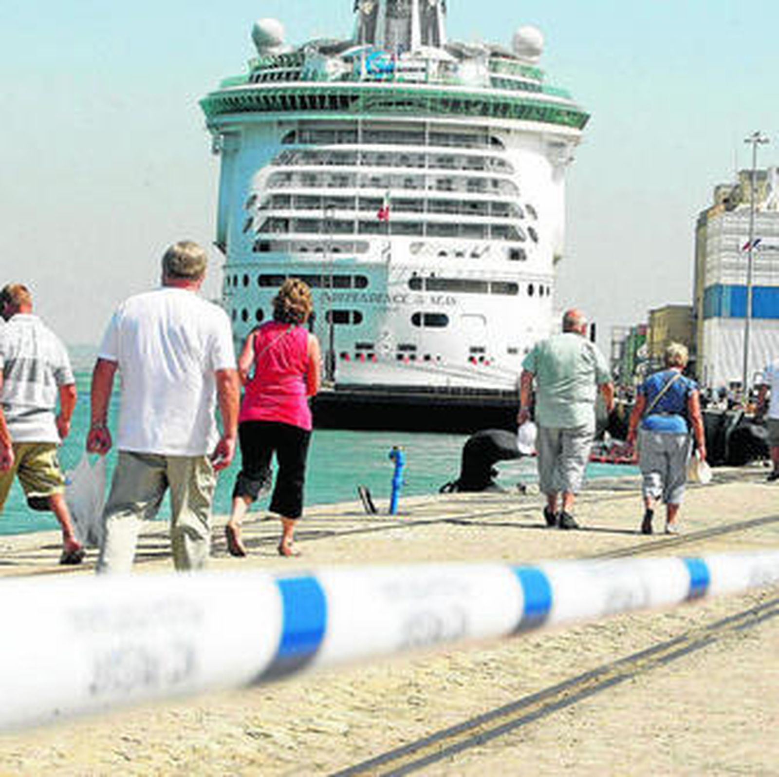 Los cruceristas se dirigen al barco 'Independence of thes seas' atravesando las instalaciones portuarias.