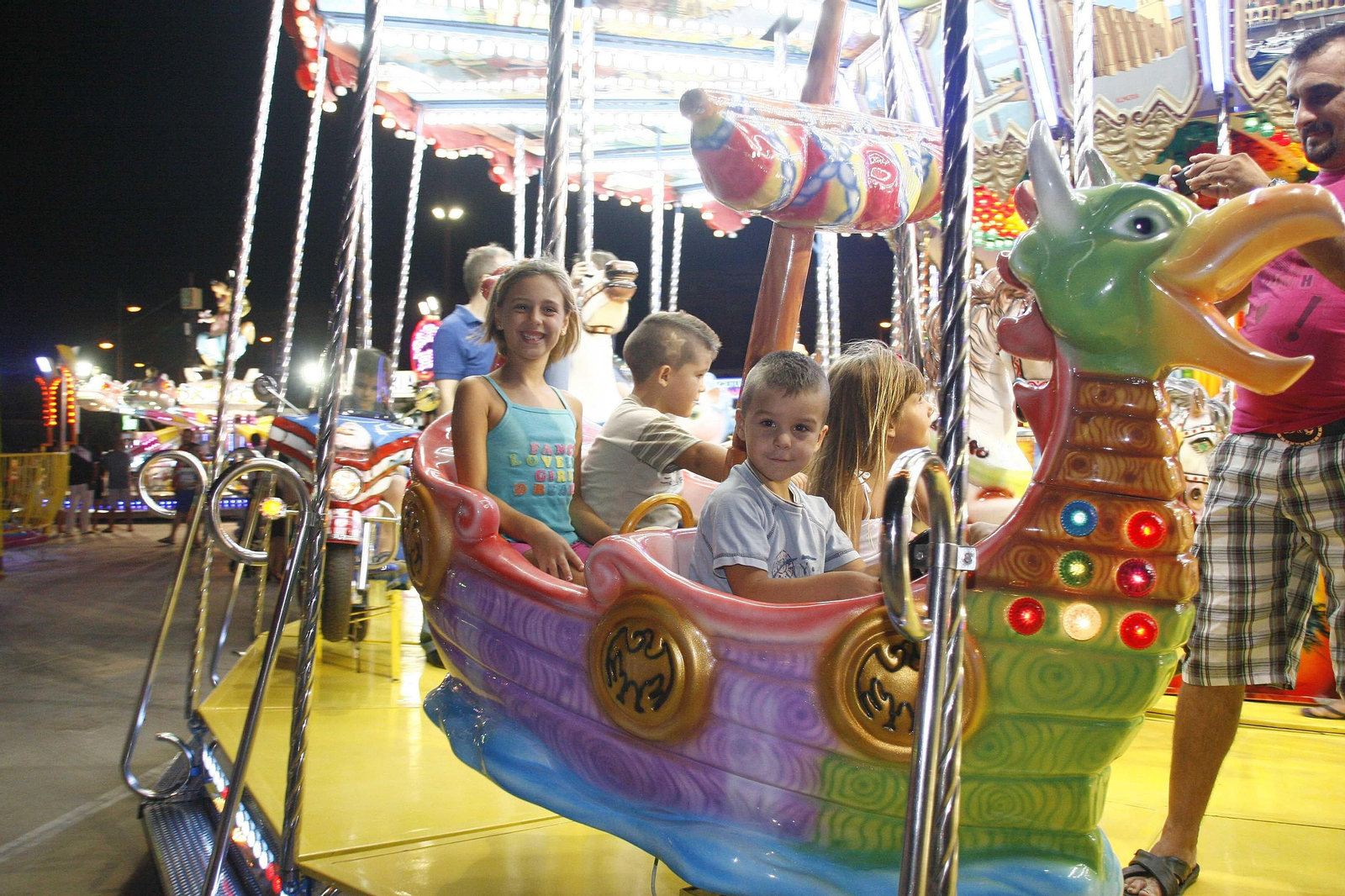 Unos niños se divierten en una atracción de feria.