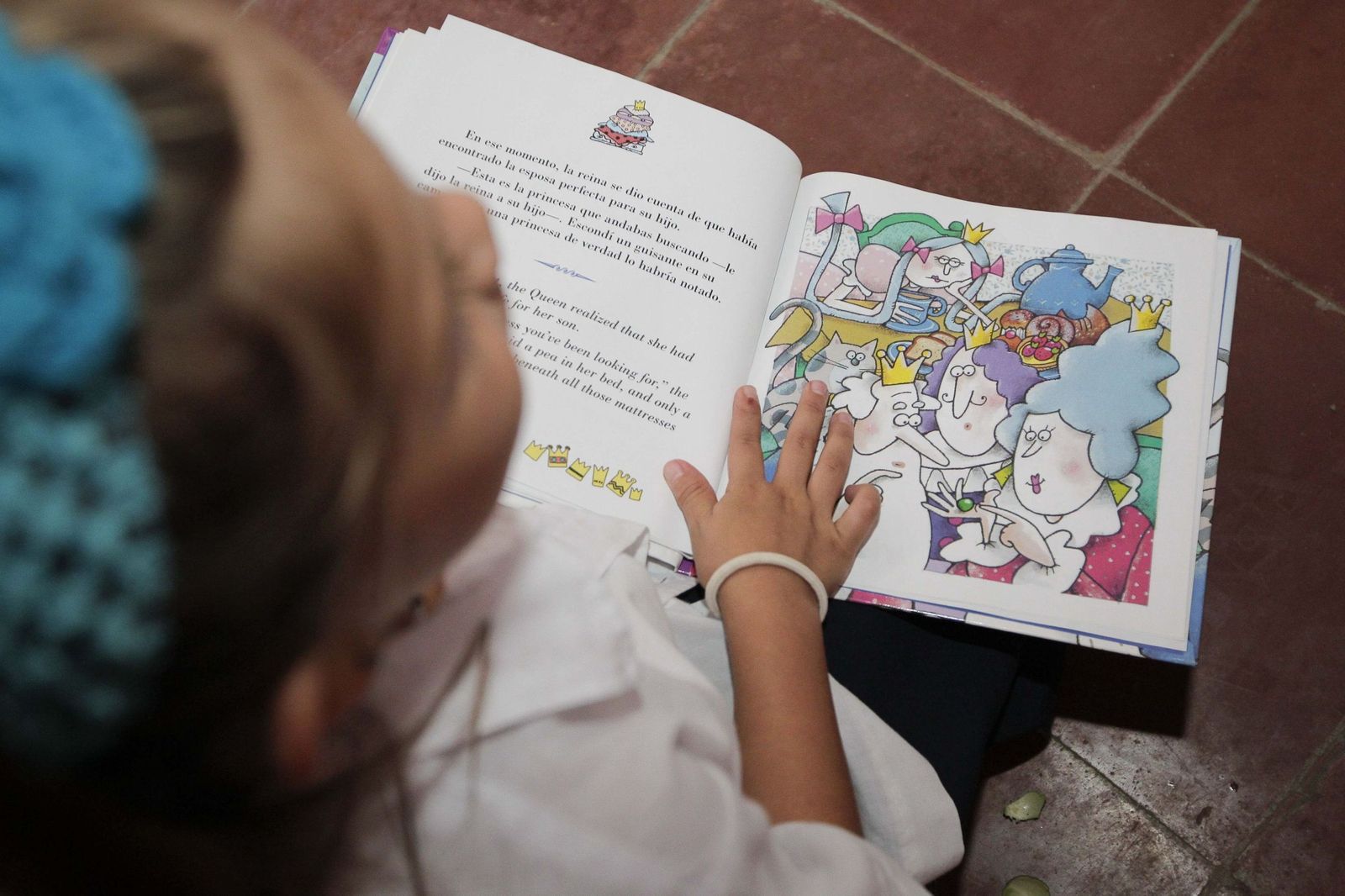 Una niña lee un libro infantil