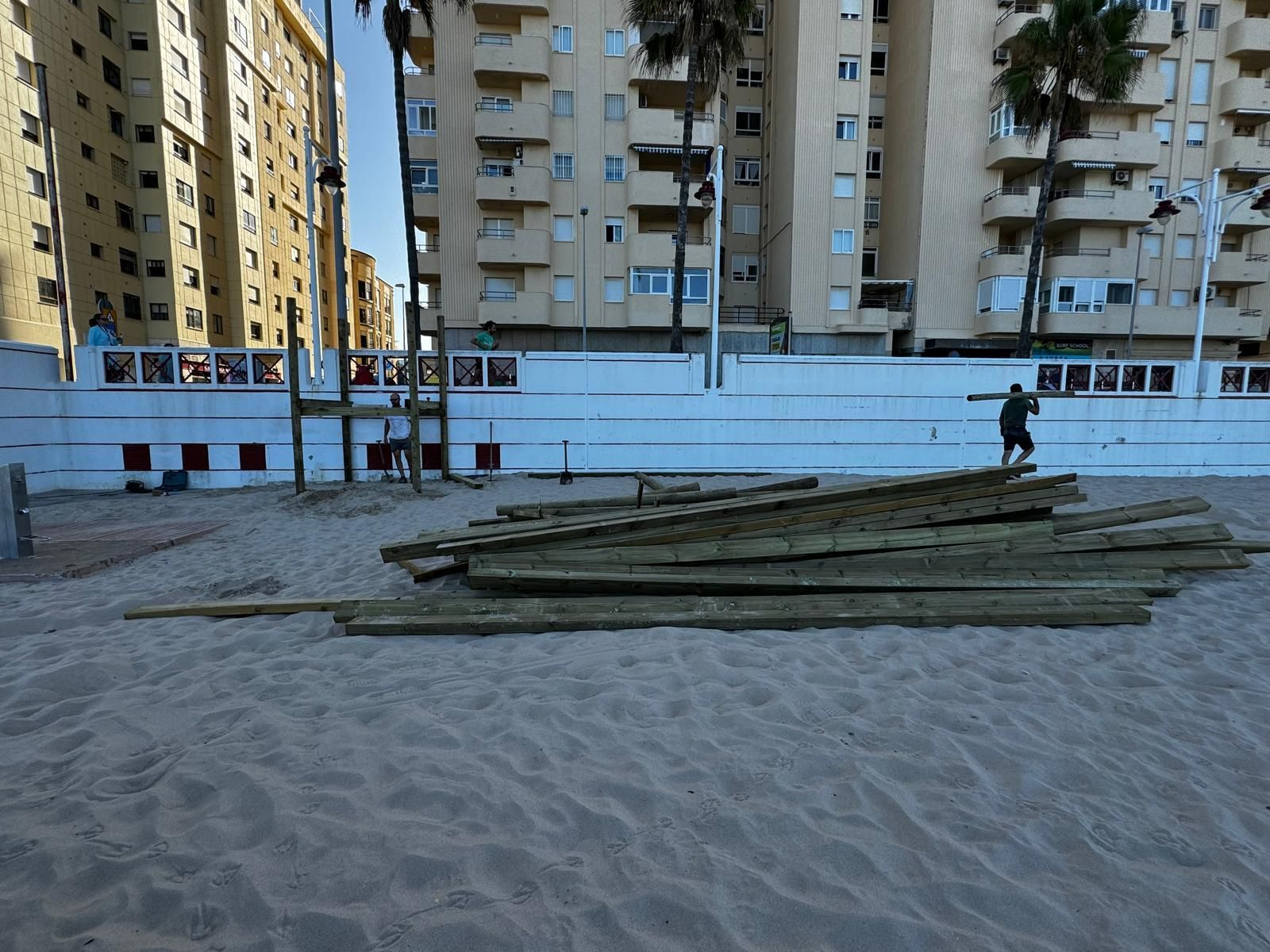 Operarios instalan el acceso para personas con movilidad reducida en la calle Caracolas.