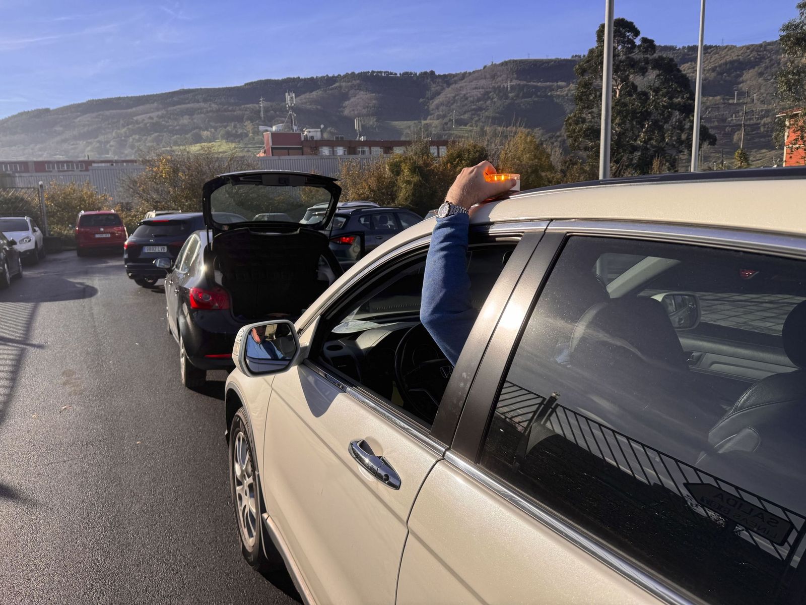 Un conductor coloca una baliza  de emergencias.
