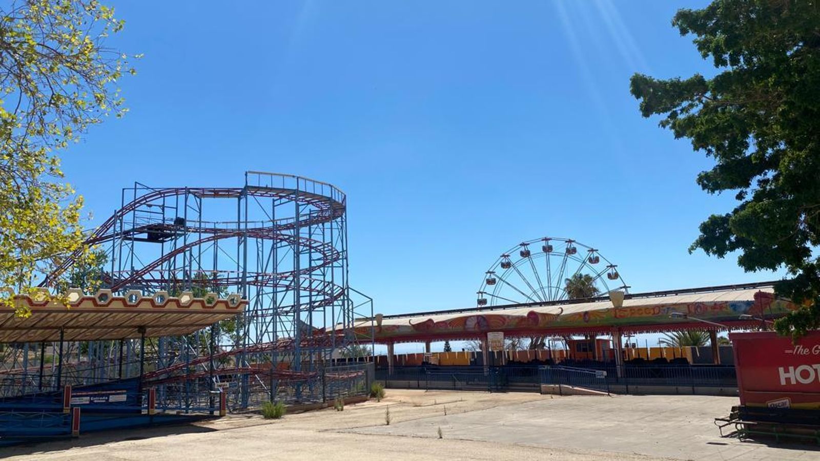 Montaña rusa, coches choques y noria de fondo tivoli