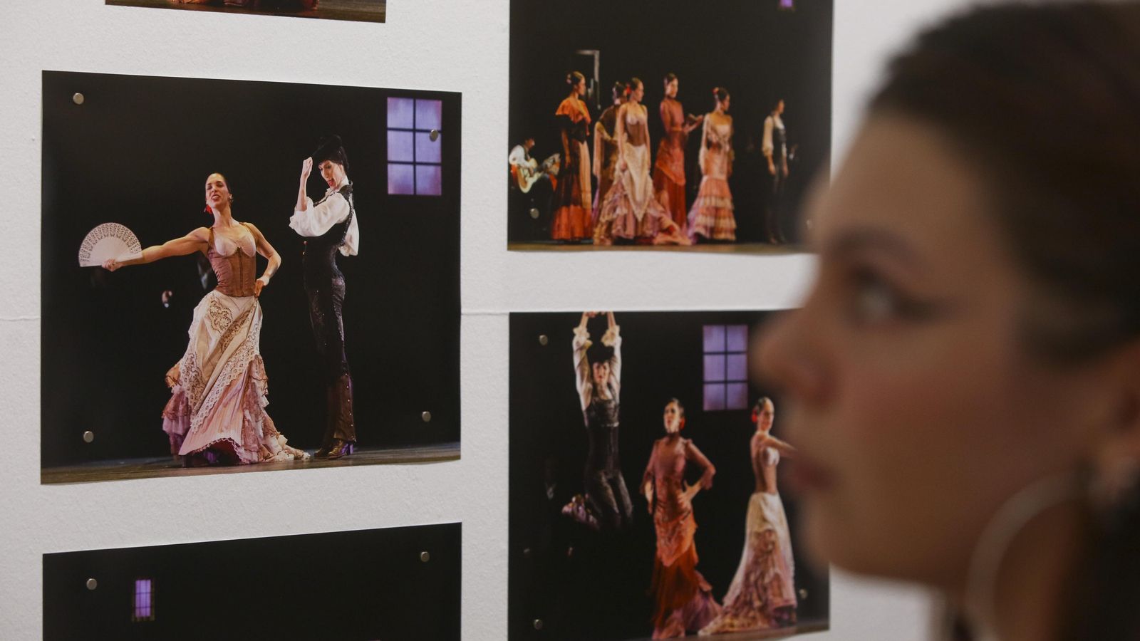 Una chica junto a una serie de fotografías de la obra teatral 'Zaguán'.