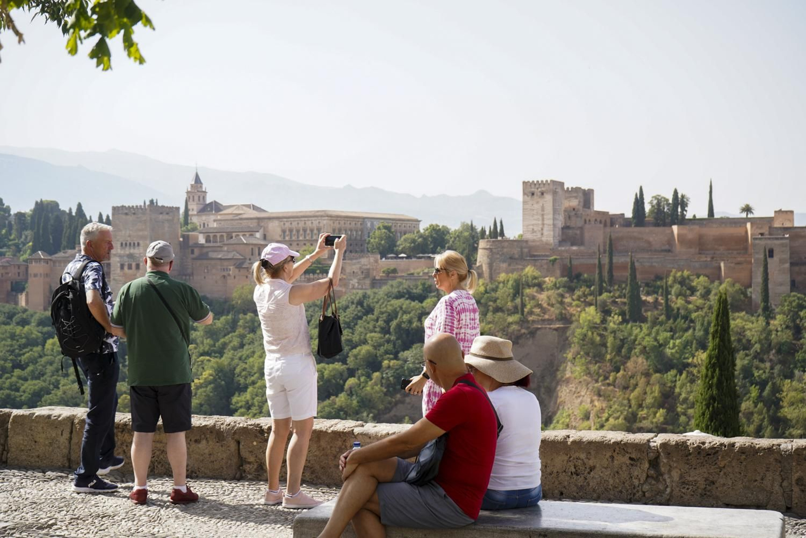 Un grupo de turistas contempla y fotografía la Alhambra desde el Mirador de San Nicolas