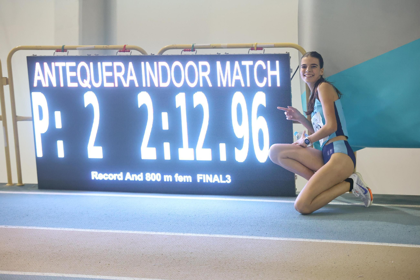 La atleta almeriense posa sobre la pista junto a su marca con la que logró batir el récord de Andalucía en categoría sub-18.