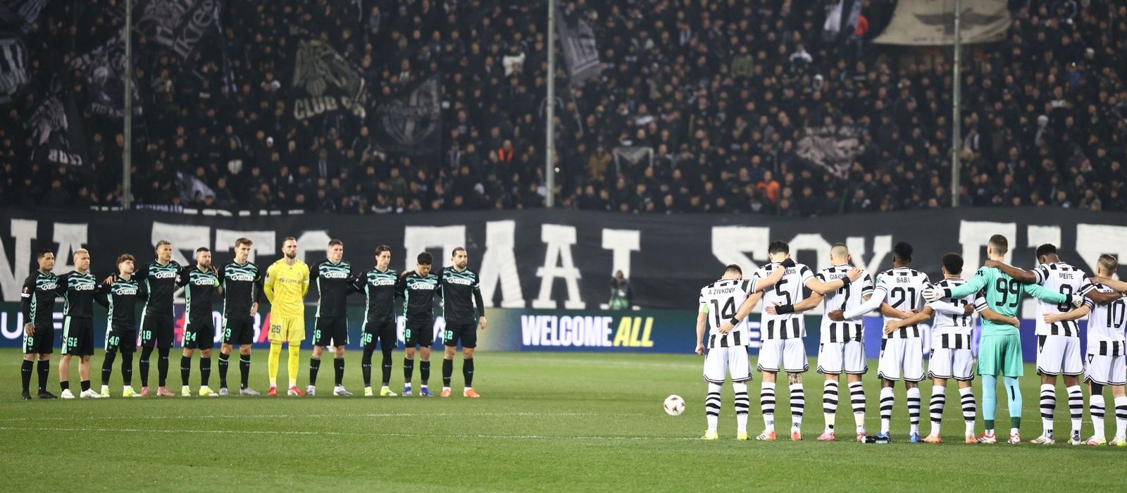Los futbolistas del Betis y del PAOK guardan un minuto de silencio por la tragedia ferroviaria.