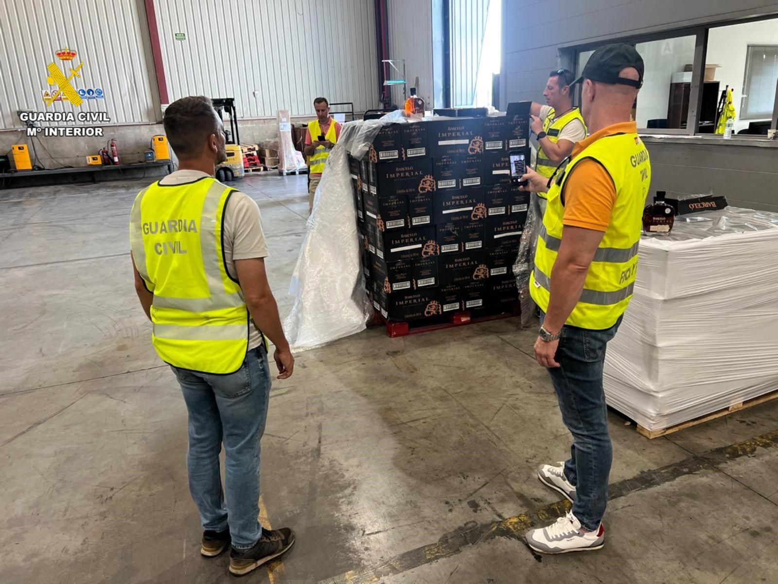 Agentes de la Guardia Civil, con el cargamento de ron incautado.
