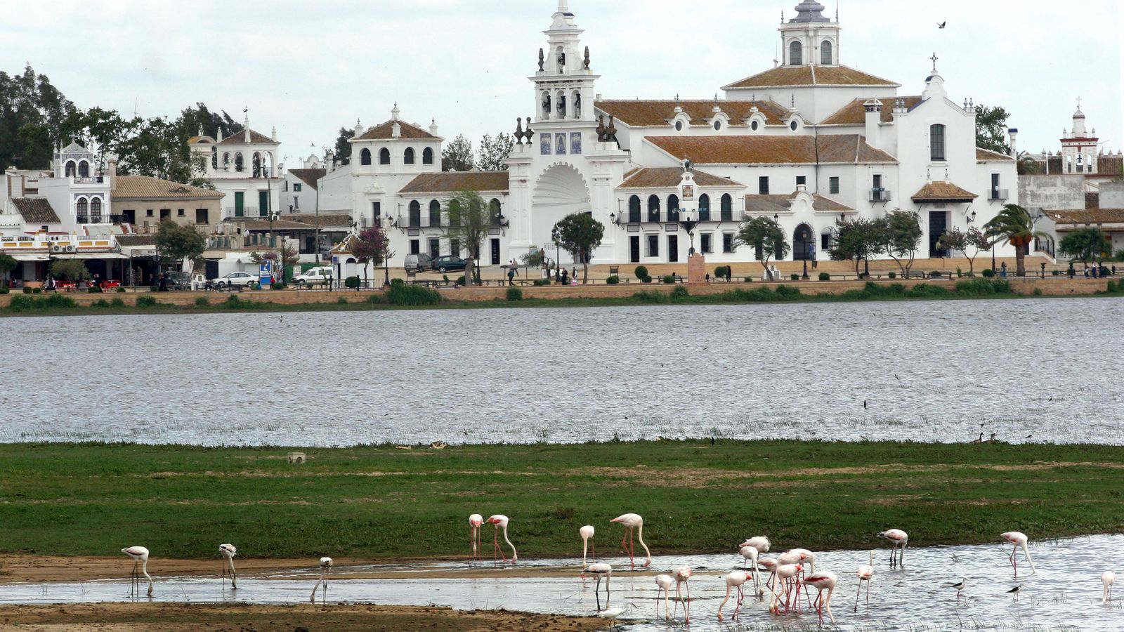 La ermita, a los pies de la marisma poblada de flamencos.