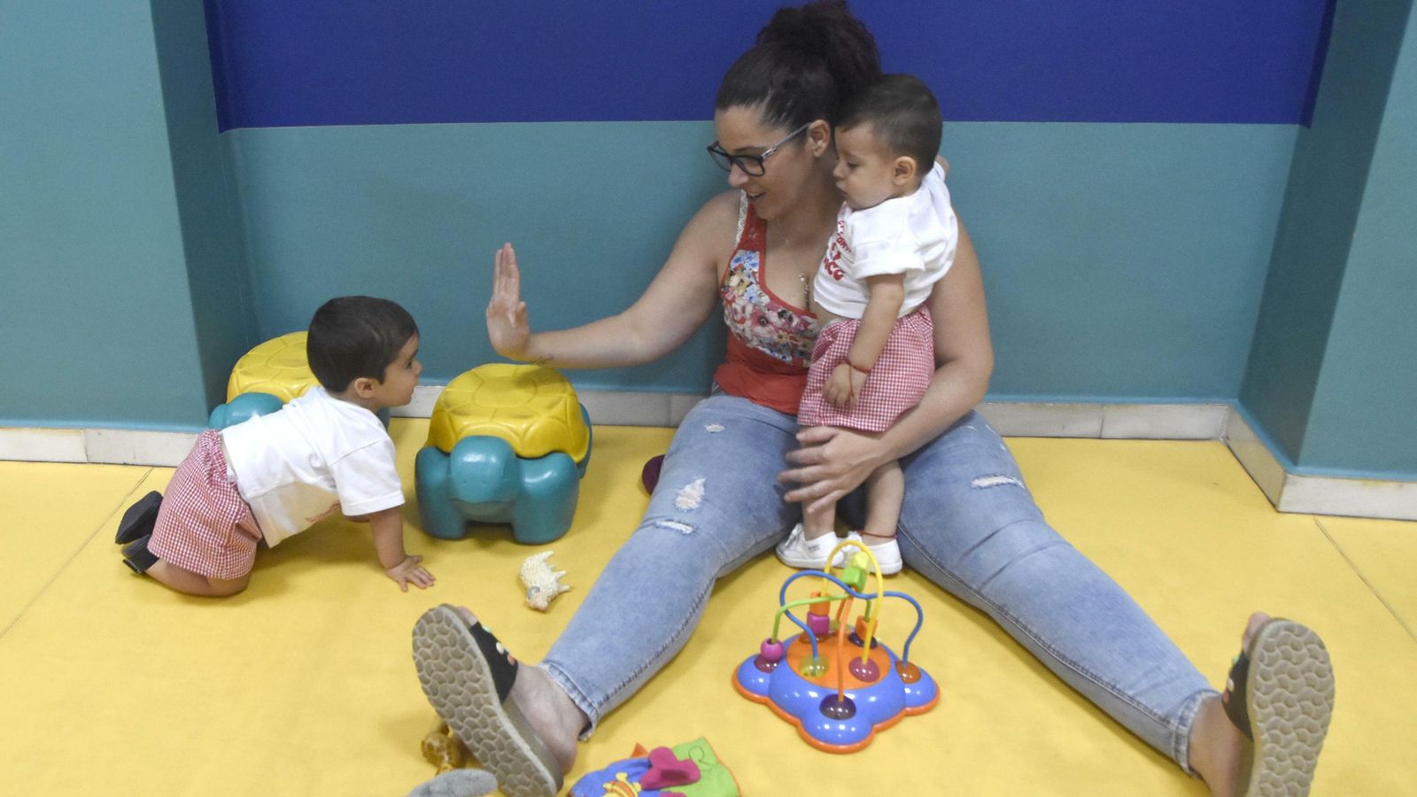 Una madre juega con los niños de la guardería. Una madre juega con los niños de la guardería.