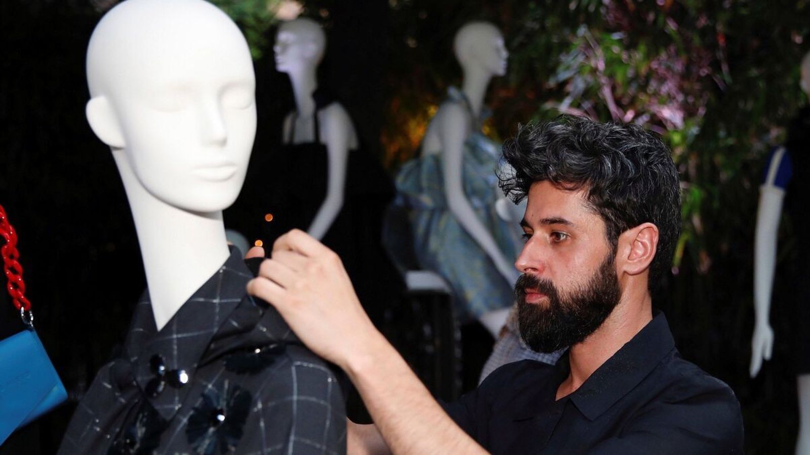 Moisés Nieto coloca una de sus prendas sobre un maniquí.
