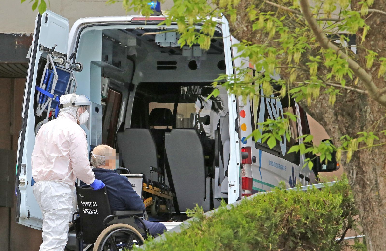 Un profesional baja a un paciente de la ambulancia en el hospital de Jerez.