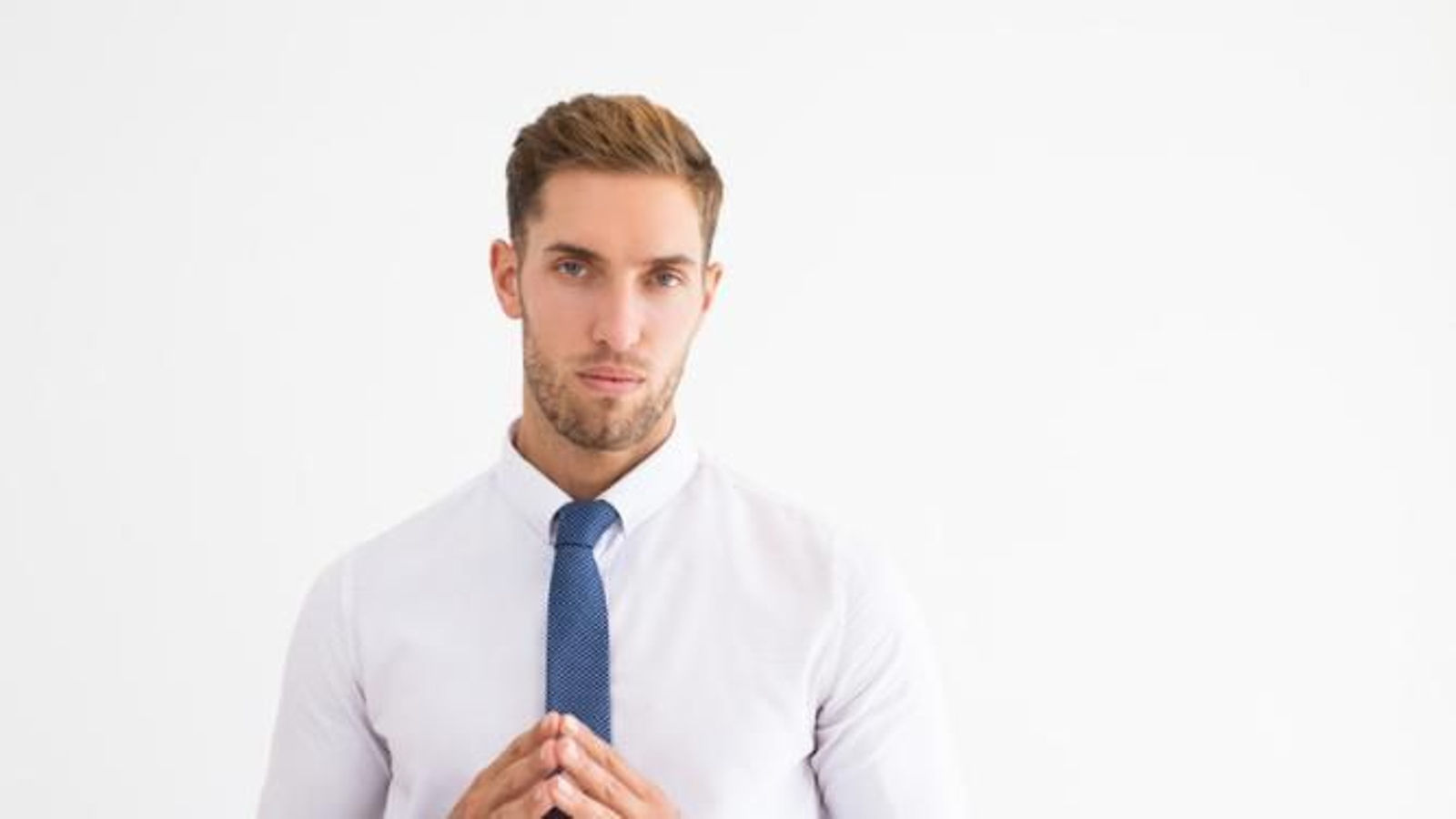 Hombre ejecutivo con mirada seria y manos juntas.