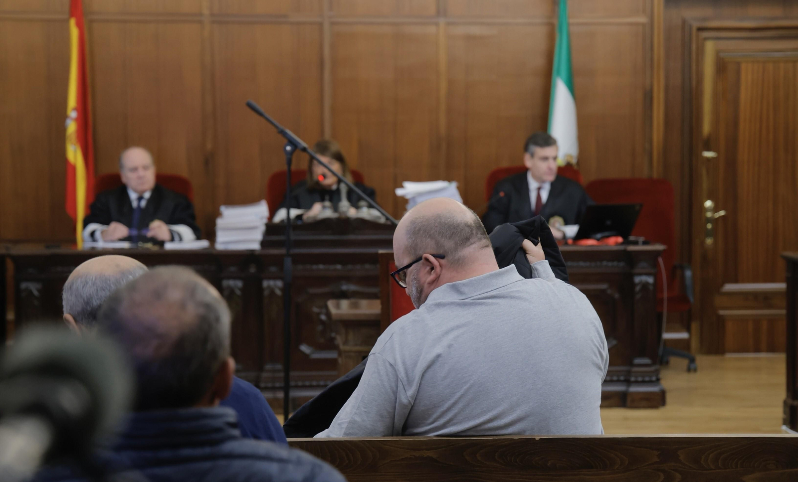 Juan Francisco Trujillo, de espaldas a la cámara, frente al tribunal de la Sección Primera de la Audiencia de Sevilla durante la primera sesión del juicio, celebrada este lunes.