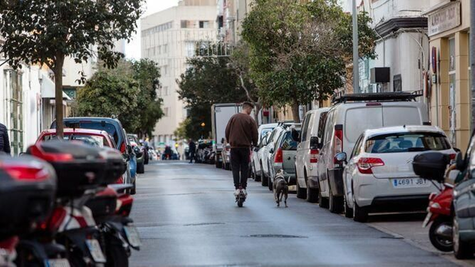 Un chico con un patinete por la avenida de Portugal.