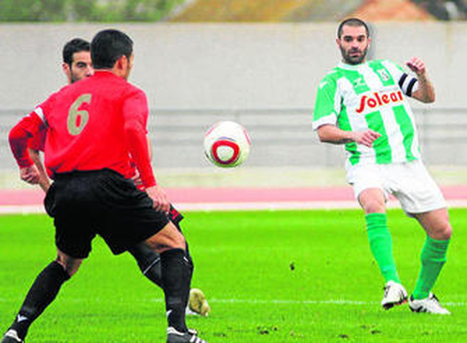El capitán verdiblanco, Abel Luque, mira la pelota tras golpearla.