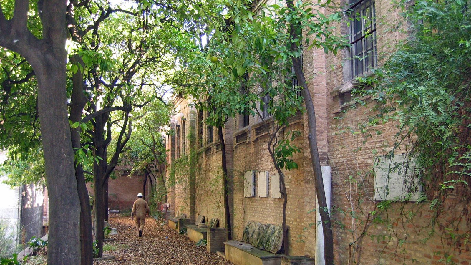 Los jardines que cobijan la torre, diseñados por Talavera, con la medianera de una de las naves que lo rodea.