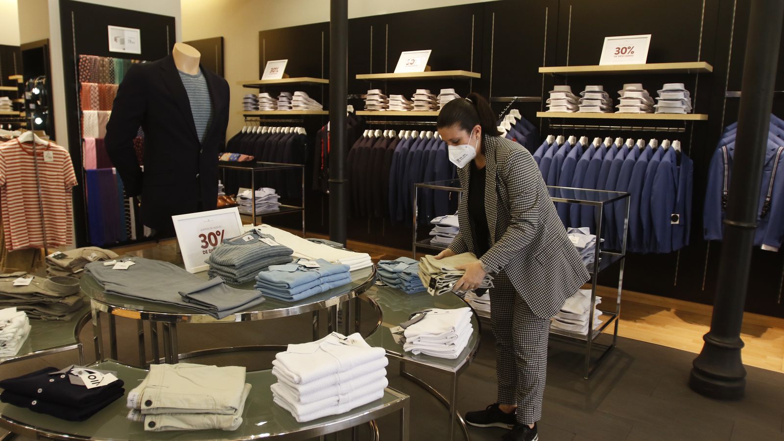 Raquel Baena, de la tienda de ropa masculina Puro Ego, coloca varias prendas.