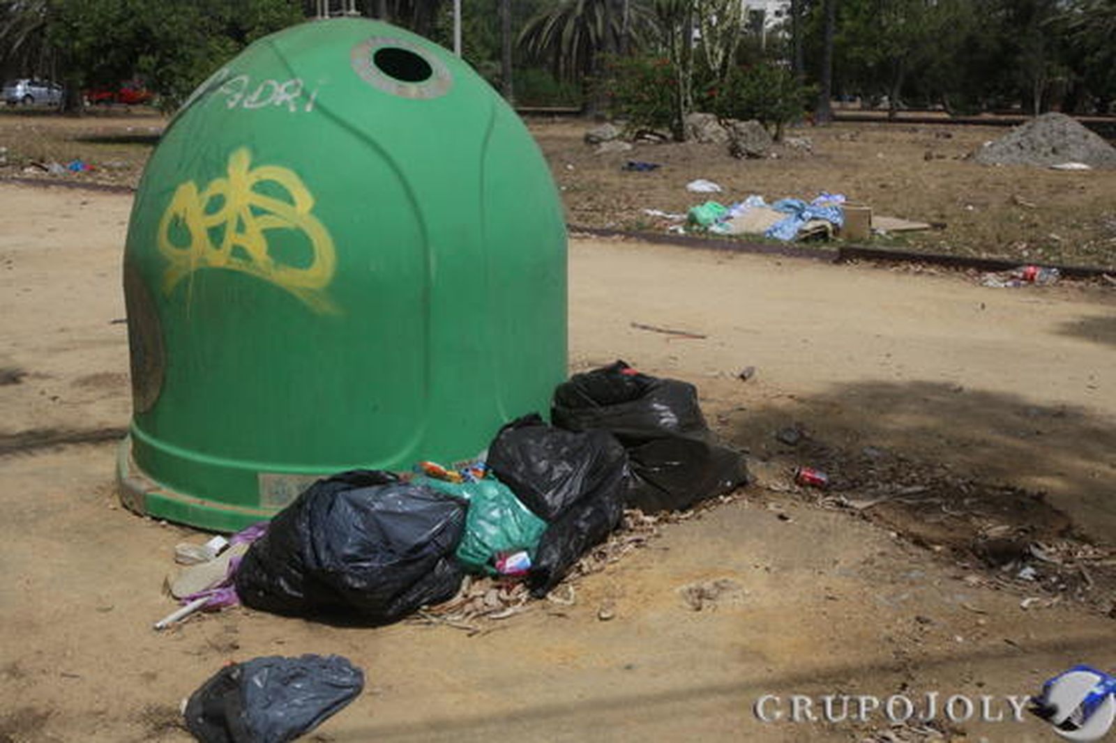 Imagen del contenedor de vidrio, que a sus pies se encuentran bolsas de restos de basura.

Foto: Paco Guerrero