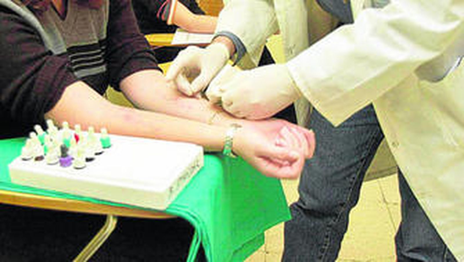 Un trabajador sanitario realiza las pruebas de la alergia a una paciente.