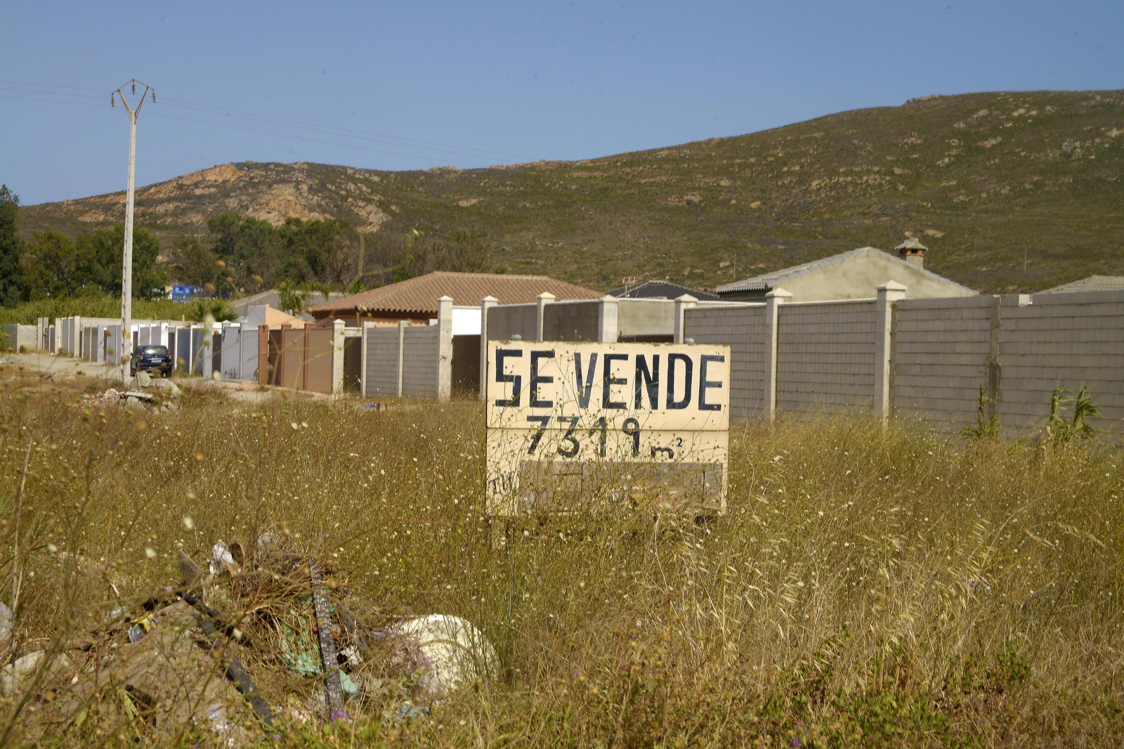 Una parcela, con un viejo cartel de "se vende".