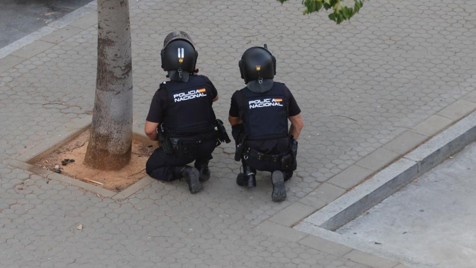 Dos policías observan la situación a distancia.