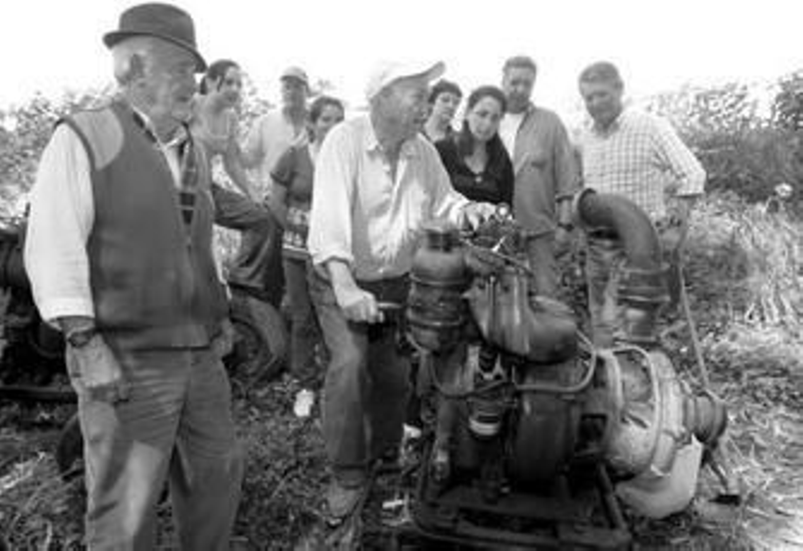 Antonio González, en primer plano, aparece junto a la máquina que manipula Francisco para extraer agua. Le acompañan un grupo de agricultores afectados.