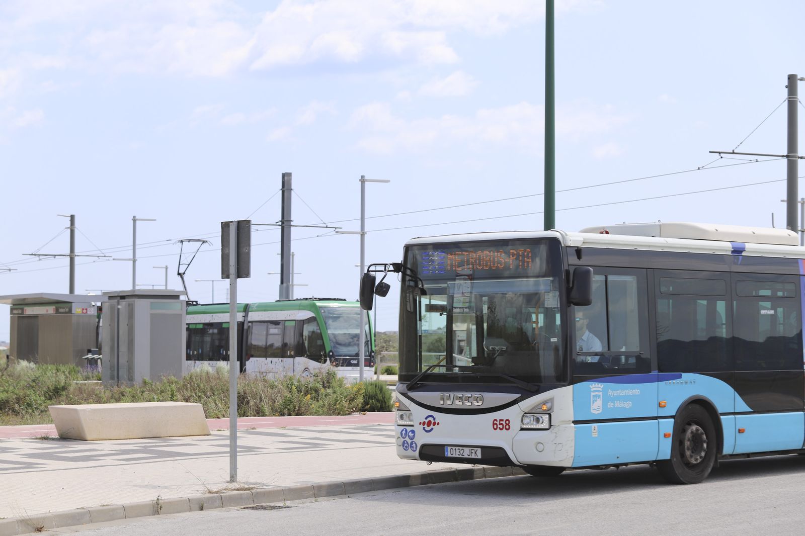 Uno de los trenes del Metro, al fondo, y un autobús de la EMT, en primer plano.
