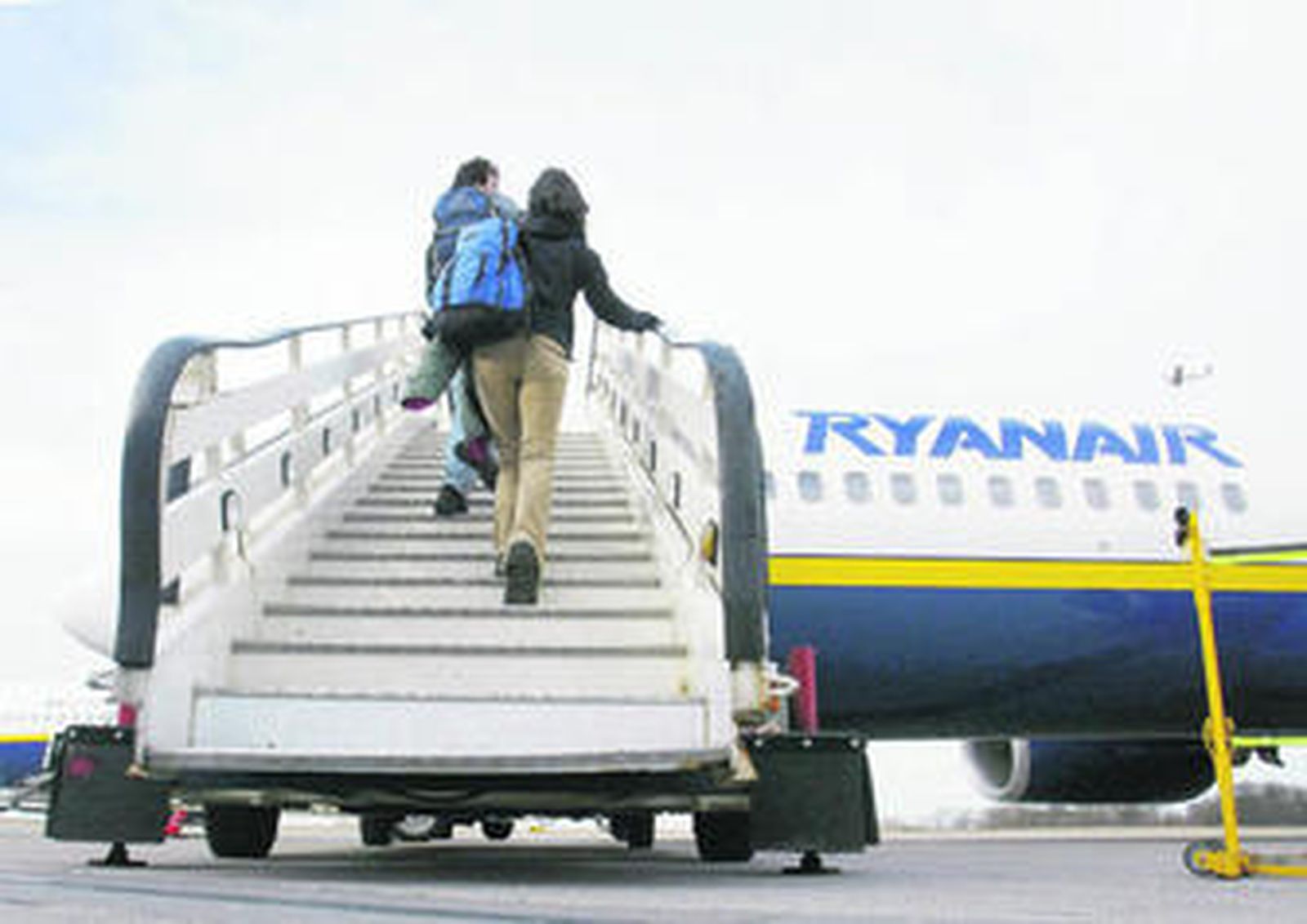 Dos pasajeros suben a bordo de un avión de Ryanair.