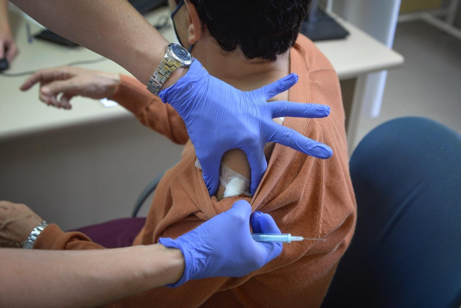 Una enfermera coloca el algodón en el brazo de una persona justo tras haber recibido el pinchazo de AstraZeneca.