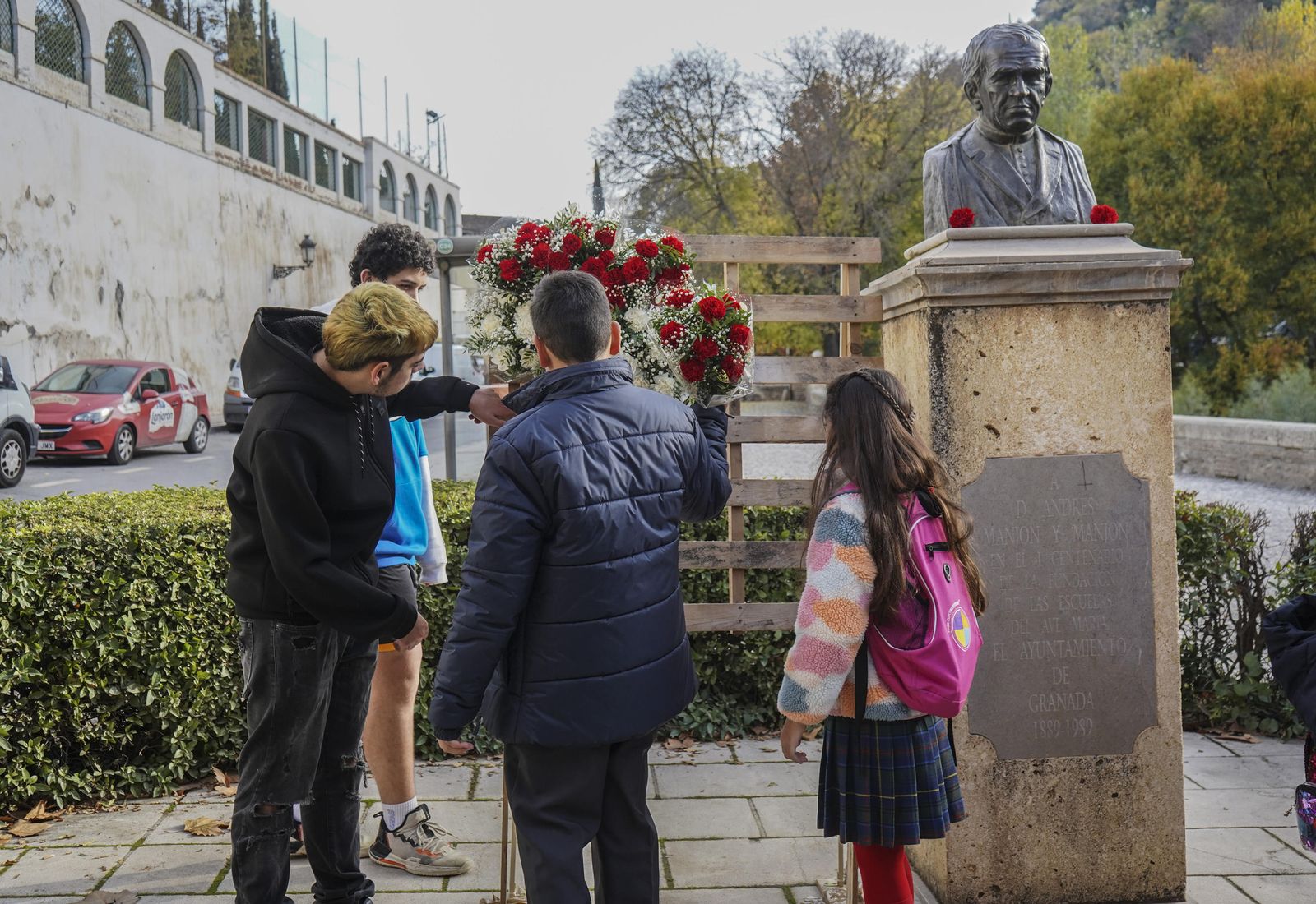 Un grupo de alumnos ofrece flores al busto del Padre Manjón