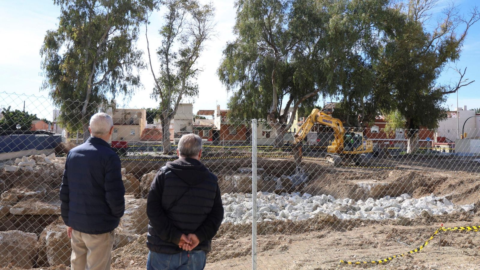 Dos vecinos miran las obras del nuevo centro de salud y el CARE.