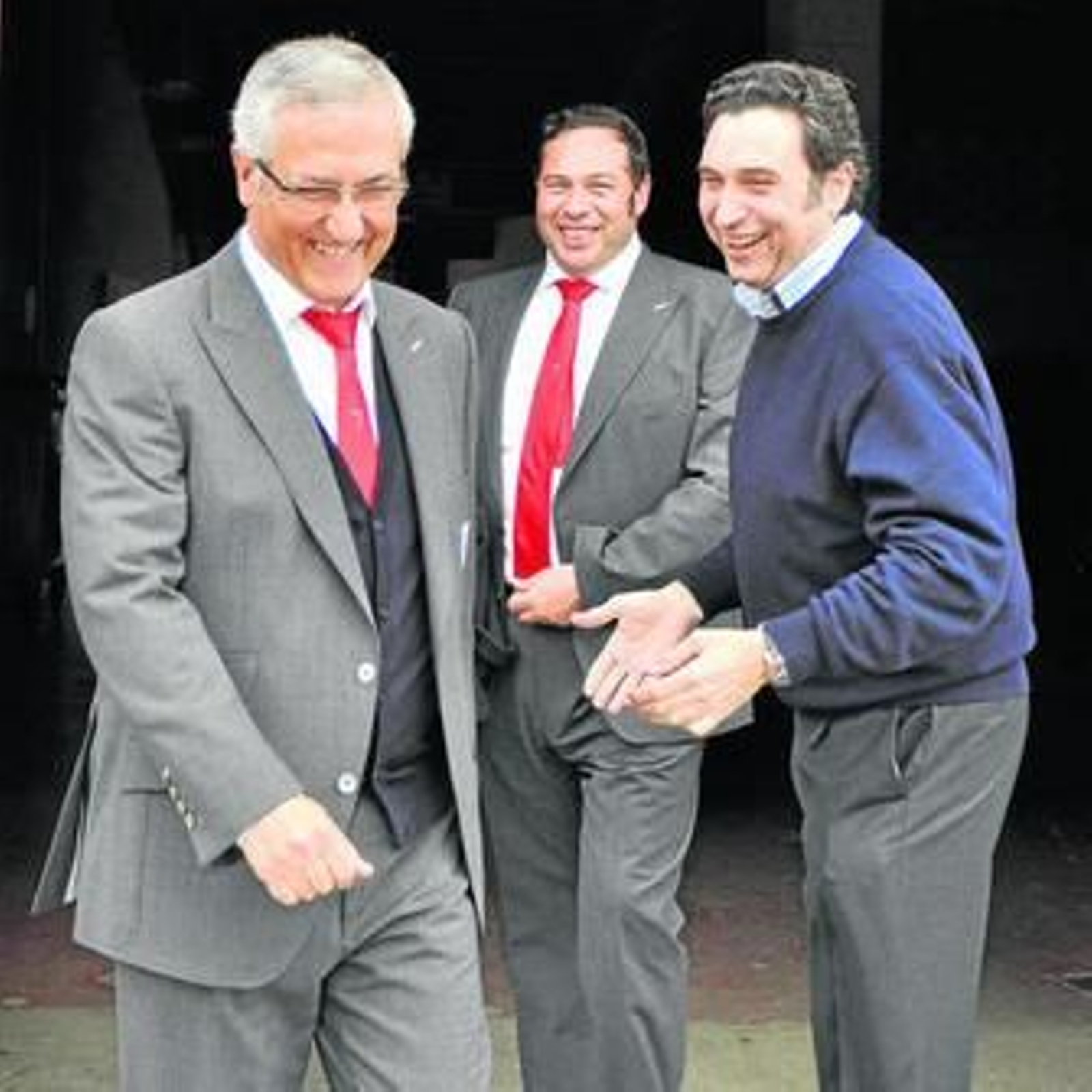 Manzano, seguido por el jefe de prensa, Jesús Gómez, sonríe ante el encargado de la tienda oficial.