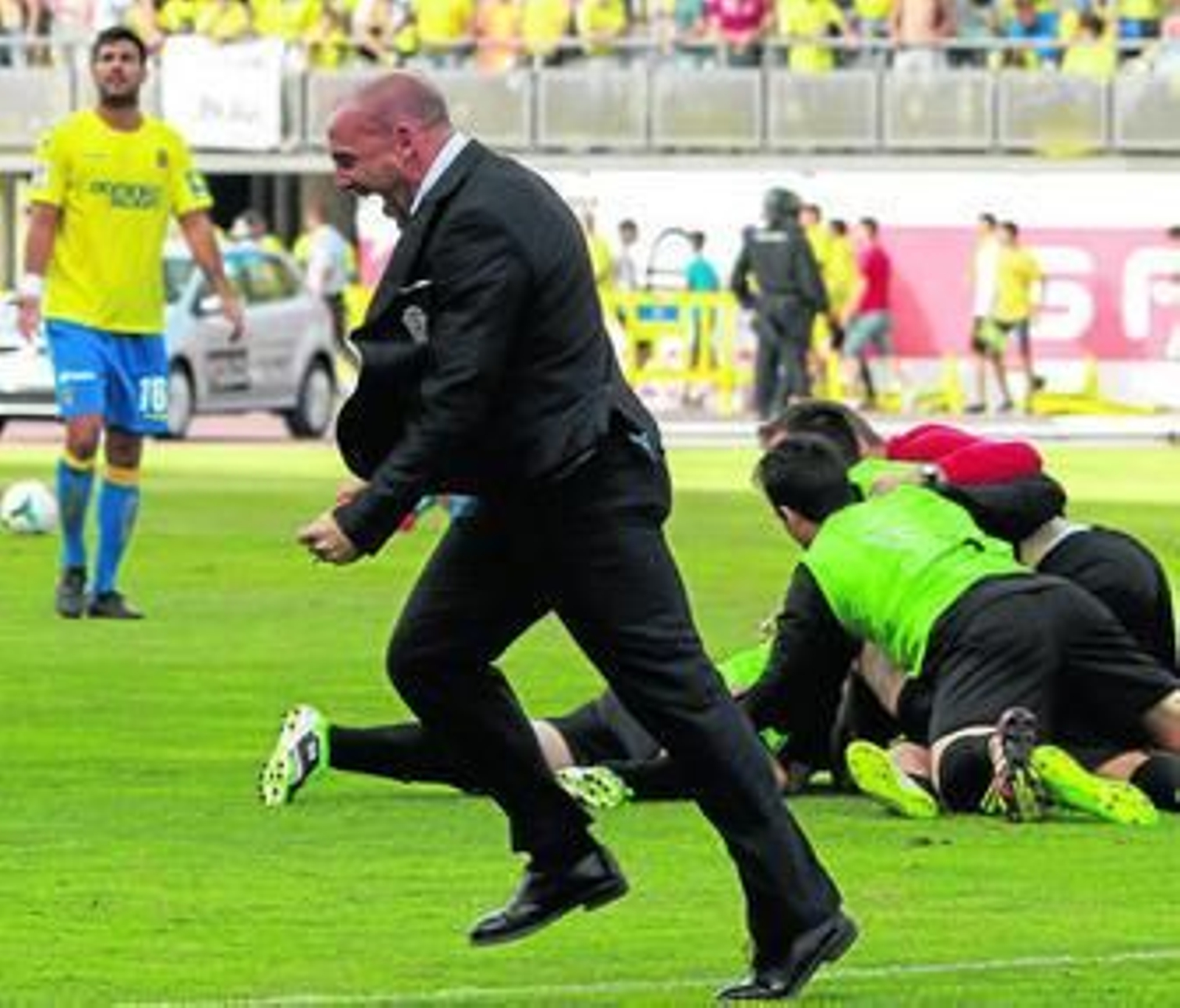 El técnico del Córdoba, Albert Ferrer, celebra el ascenso, con los jugadores haciendo una piña justo detrás.