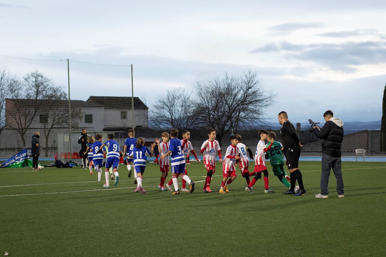 Jugadores de Granada CF y Arenas de Armilla saludándose antes de comenzar la final del torneo.