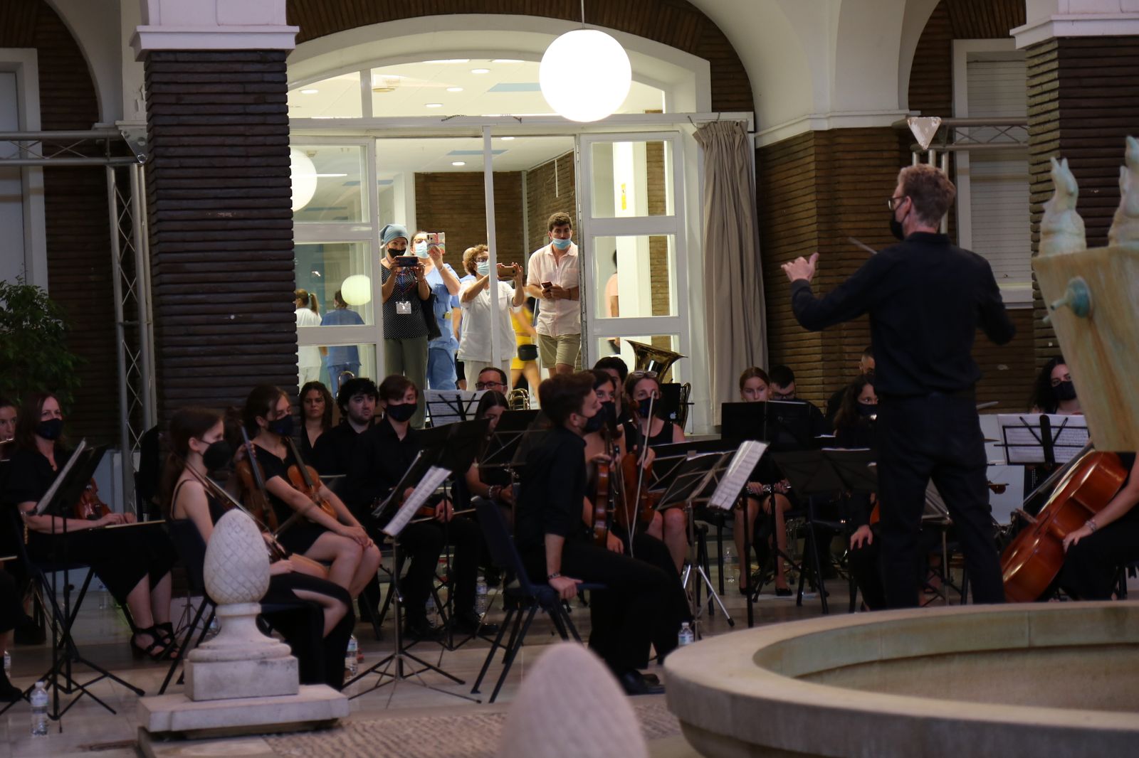 Varios profesionales contemplan desde las ventanas el acto homenaje en el virgen del Rocío.