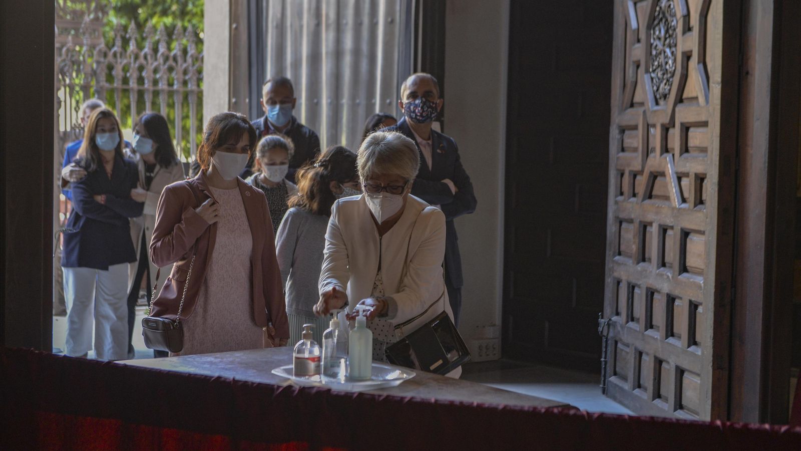 Una señora se echa gel hidroalcohólico al entrar en el Salvador.