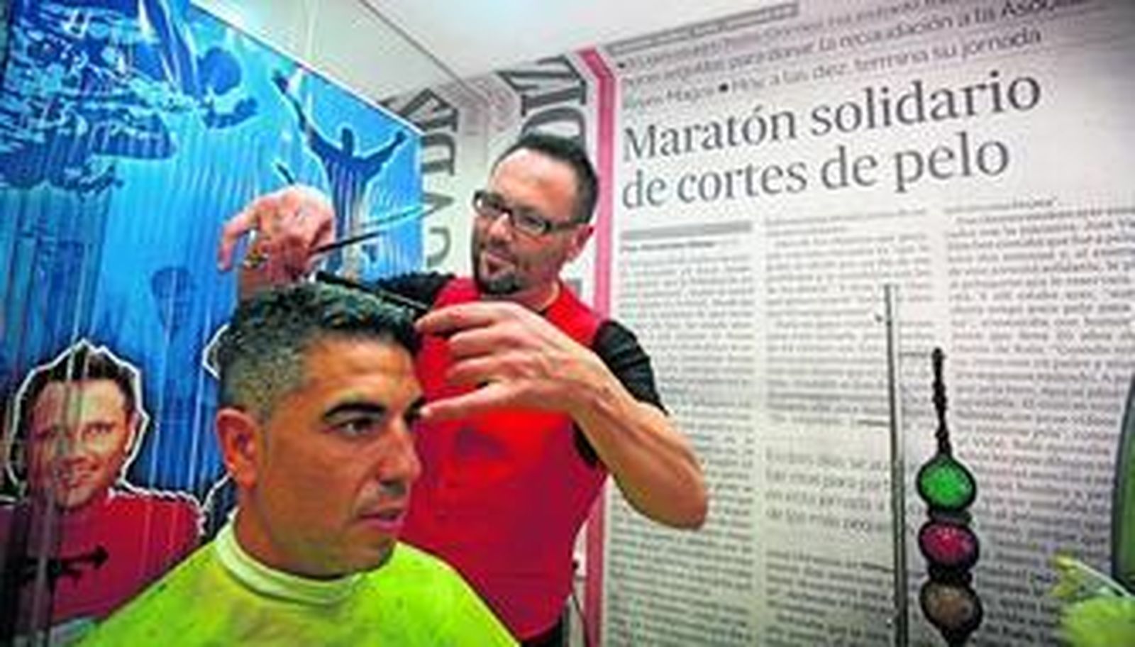 Rafa Gómez cortando el pelo ayer a uno de sus clientes solidarios en su peluquería de la calle Pintor Zuloaga.