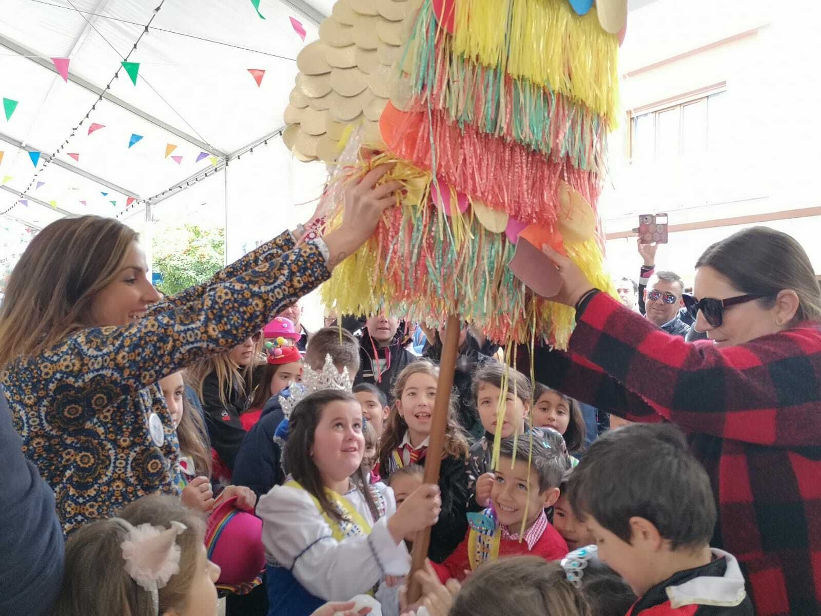 La reina infantil, Ana Soto, rompe una de las piñatas del Paseo de las Flores.