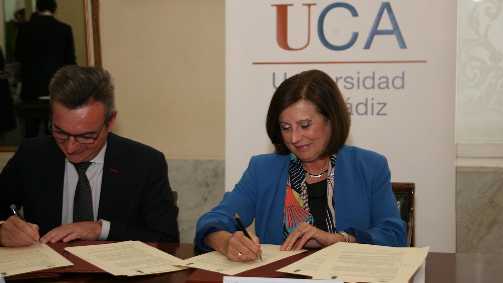 La consejera y el rector en la firma un protocolo.