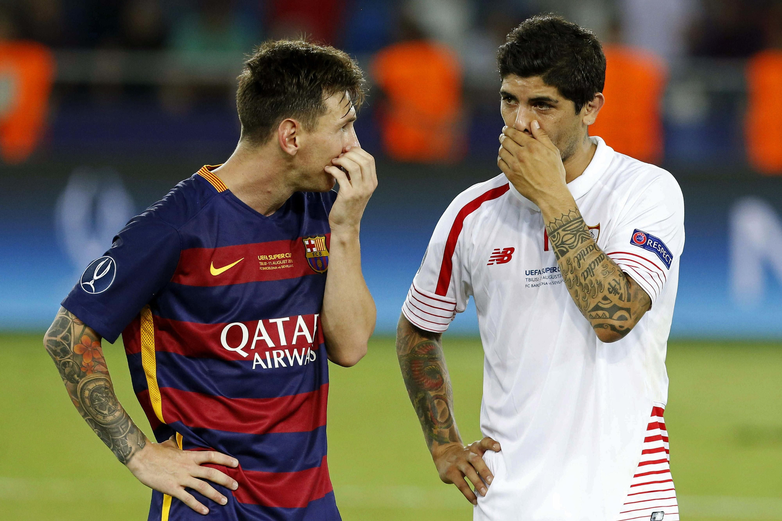 Messi y Banega, líderes de Barcelona y Sevilla, charlan durante la Supercopa de Europa en Tiflis.