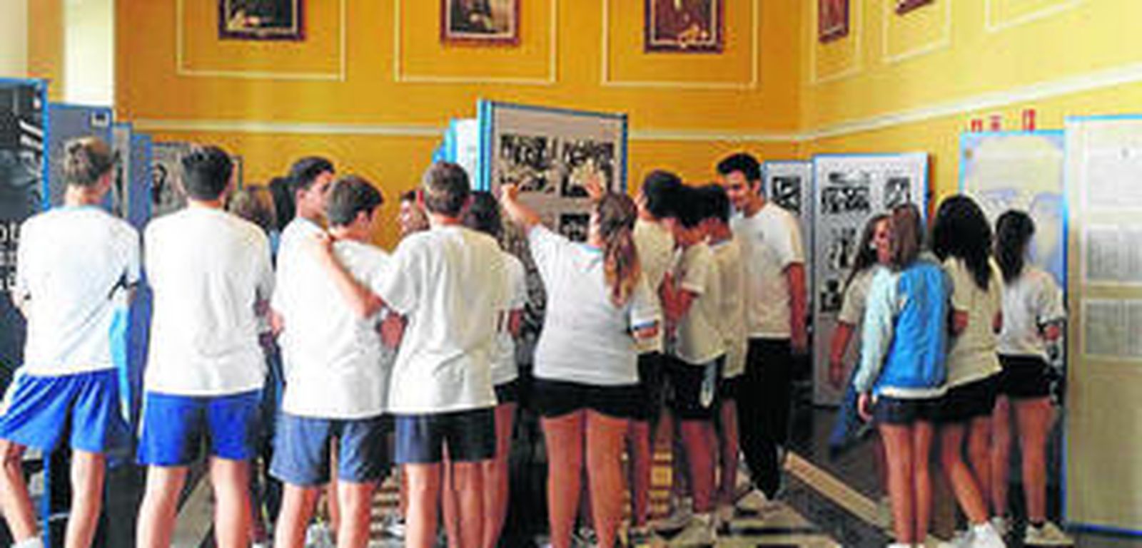 Alumnos del colegio SAFA observan las fotos en el atrio del Ayuntamiento.