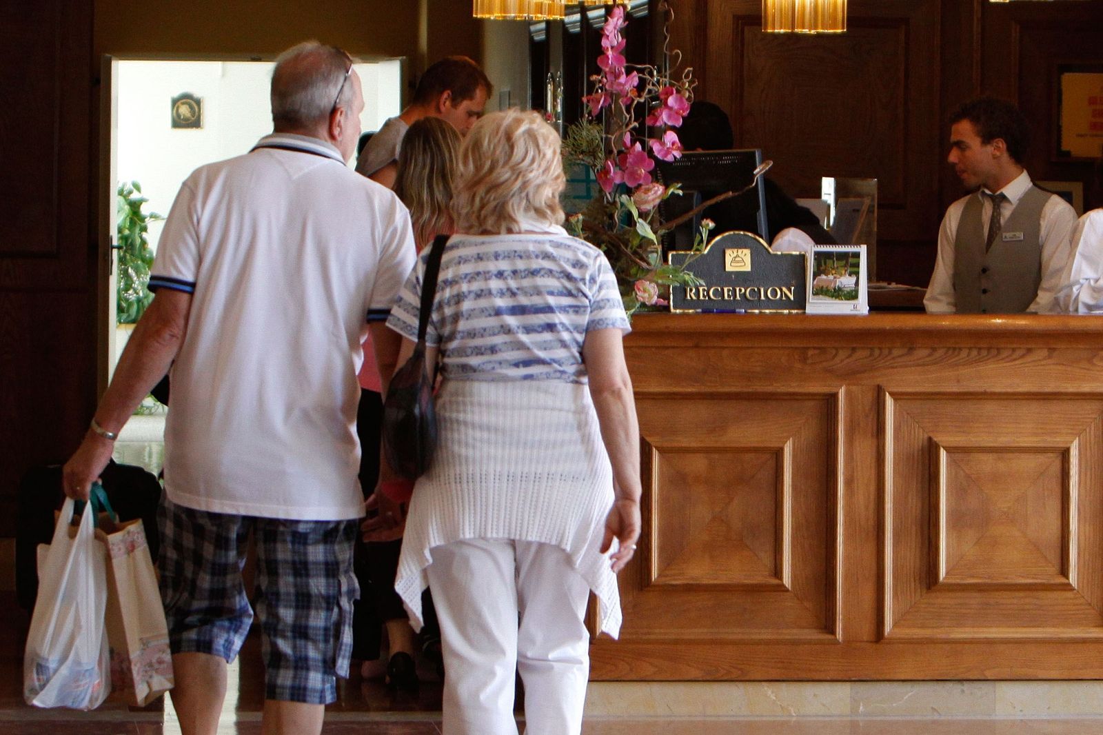 Turistas en la recepción de un hotel en Chiclana.