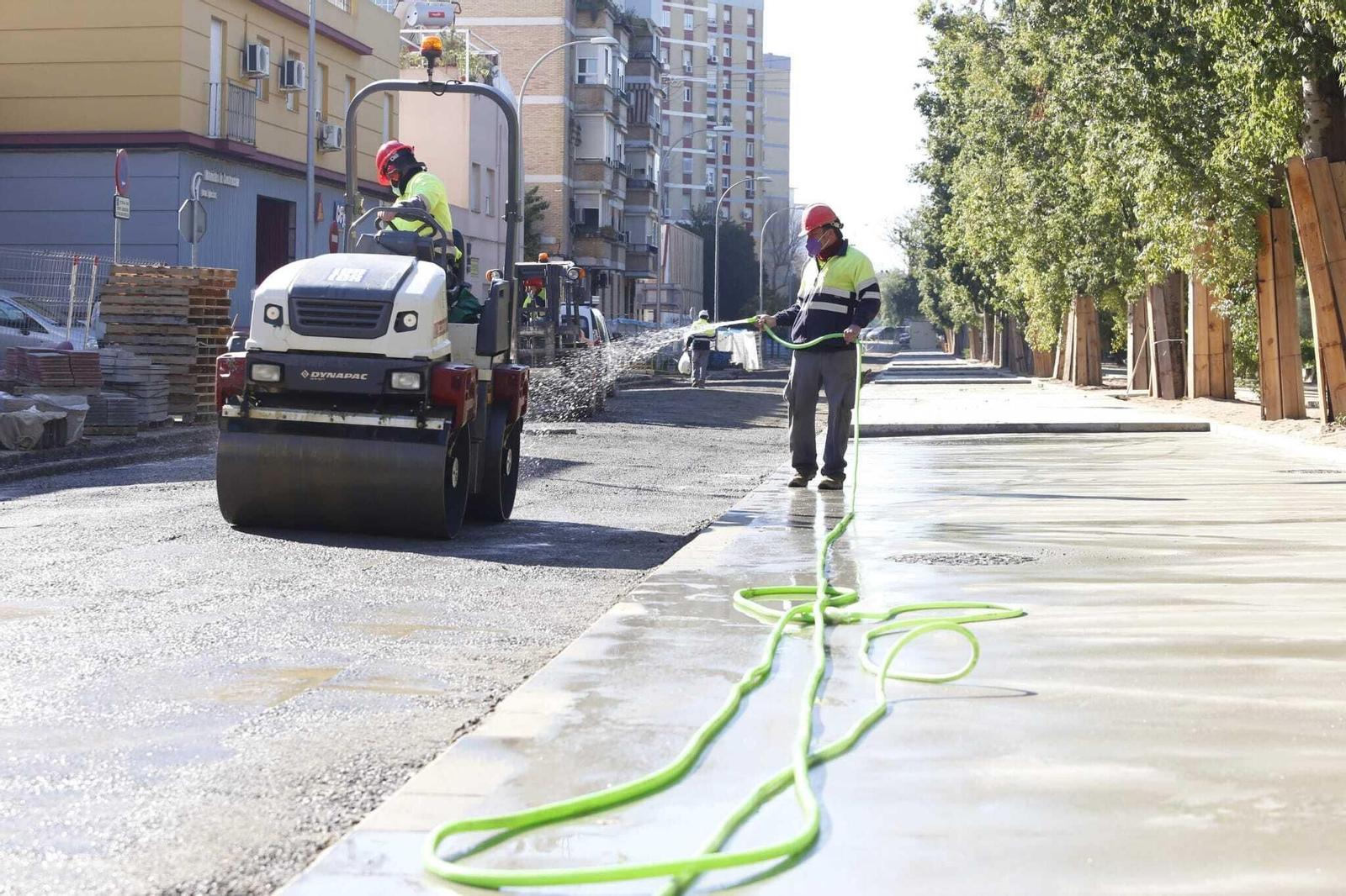 Un operario riega la obra de la Ronda de Tejares.